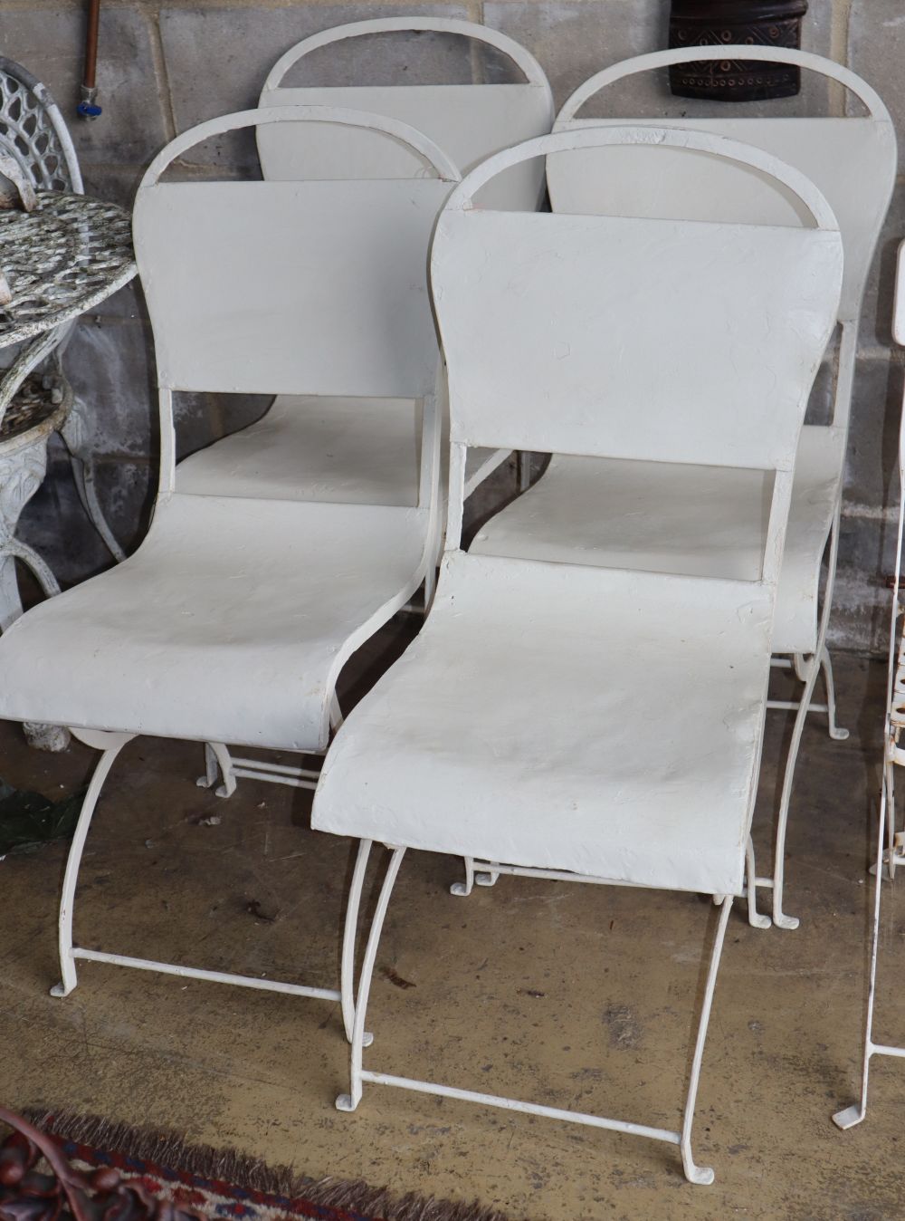 A set of four painted metal garden chairs